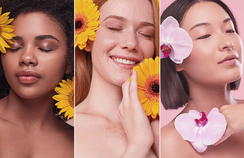 Three women with flowers on their faces, showcasing natural beauty.